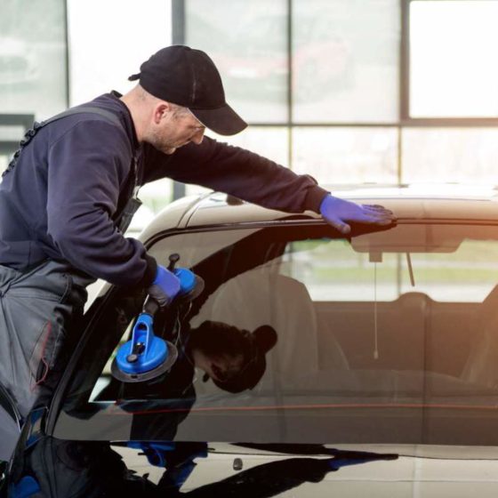 Tecnico durante la sostituzione di un parabrezza auto